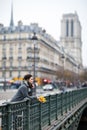 Beautiful lonely brunette girl in Paris, standing alone in a gray coat