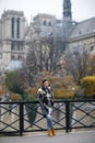 Beautiful lonely brunette girl in Paris, standing alone in a gray coat