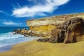 Beautiful lonely wild empty secluded sand beach at rough south-east coast, jagged rocks, steep cliff, clear blue sky - Jandia