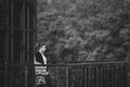 Beautiful lonely woman with hair developing in the wind and full lips on the bridge on a cold gray day. Black and white art photo