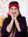 A beautiful long black hair lady with a red turban and purple blanket is sitting and smile with elegant gesture on a big dark Royalty Free Stock Photo