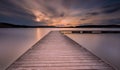 Beautiful long exposure lake with jetty at sunset.