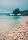 Beautiful long exposure shot of the ocean with a traditional white house in the background.Corfu Greece. Royalty Free Stock Photo