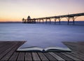 Beautiful long exposure sunset over ocean with pier silhouette c