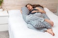 Beautiful long hair pregnant  woman with big abdomen,  sleeping on body& x27;s pillow  on the sofa indoors . Royalty Free Stock Photo