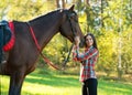 Beautiful long hair young woman with a horse outdoor