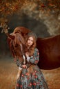 Beautiful young woman in national russian style with red draft horse