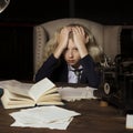 Beautiful long haired curly blonde schoolgirl tiredly learns homework in a classic vintage interior room, sitting at a table Royalty Free Stock Photo