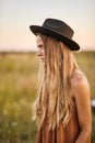 beautiful long-haired woman in dress and hat having rest enjoying trip at summer