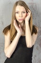 Beautiful long-haired young blonde woman with a slender figure in a black mini dress Royalty Free Stock Photo