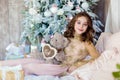 Beautiful long-haired young girl holding a Teddy bear smiles on Royalty Free Stock Photo