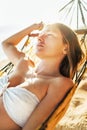Beautiful longhaired young woman losting in dream rest in hammock. Sunny portrait