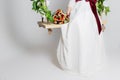 Beautiful lovely bride is sitting on a swing with a beautiful bouquet of colorful flowers in a white dress with evening hairstyle Royalty Free Stock Photo