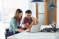 Beautiful lovely young couple using their laptop and having breakfast in the kitchen at home