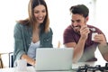 Beautiful lovely young couple using their laptop and having breakfast in the kitchen at home Royalty Free Stock Photo