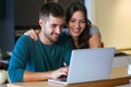 Beautiful lovely young couple using their laptop in the kitchen at home. Royalty Free Stock Photo