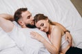 Beautiful couple kissing in bed. Young happy family lying together Royalty Free Stock Photo
