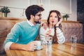 Beautiful loving couple sitting in a cafe drinking coffee and conversating Royalty Free Stock Photo