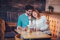 Beautiful loving couple sitting in a cafe drinking coffee and conversating Royalty Free Stock Photo