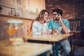 Beautiful loving couple sitting in a cafe drinking coffee and using phone Royalty Free Stock Photo
