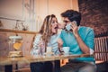 Beautiful loving couple sitting in a cafe drinking coffee and using phone Royalty Free Stock Photo