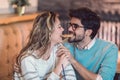 Beautiful loving couple sitting in a cafe sharing cookie.