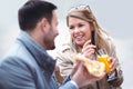 Beautiful loving couple sitting in outdoor cafe and eating pizza