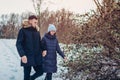 Beautiful loving couple walking in winter forest together. People having fun outdoors Royalty Free Stock Photo