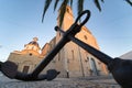 Beautiful low angle shot of a church with an anchor statue in front of it under the tree Altea Spain