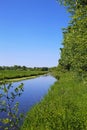 Beautiful lower rhine summer landscape with river Niers, green meadow and trees, blue sky - Viersen, Germany