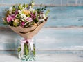 Beautiful lush bouquet with different spring flowers, turquoise background, gift