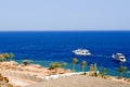 Beautiful luxurious white big yachts sail on the blue salt sea against the backdrop of palm trees and a beach on the beach in a tr Royalty Free Stock Photo