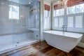 Beautiful luxury bathroom with large white tub and white tile walk in shower Royalty Free Stock Photo