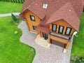 Beautiful luxury big wooden house. Timber cottage villa with with green lawn, garden and blue sky on background