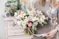 Beautiful luxury bouquet of mixed flowers in woman hand. the work of the florist at a flower shop. cute lovely girl Royalty Free Stock Photo