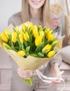 Beautiful luxury bouquet of yellow tulips flowers in woman hand. the work of the florist at a flower shop. cute lovely Royalty Free Stock Photo