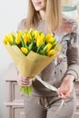 Beautiful luxury bouquet of yellow tulips flowers in woman hand. the work of the florist at a flower shop. cute lovely Royalty Free Stock Photo