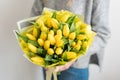 Beautiful bouquet of yellow tulips flowers in woman hand. the work of the florist at a flower shop. cute lovely girl Royalty Free Stock Photo