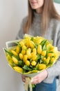 Beautiful bouquet of yellow tulips flowers in woman hand. the work of the florist at a flower shop. cute lovely girl Royalty Free Stock Photo