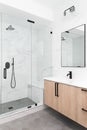 A wooden vanity with a large, marble tile shower. Royalty Free Stock Photo