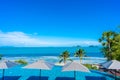 Beautiful luxury outdoor swimming pool in hotel resort with sea ocean around coconut palm tree and white cloud on blue sky Royalty Free Stock Photo