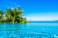 Beautiful luxury outdoor swimming pool in hotel resort with sea ocean around coconut palm tree and white cloud on blue sky Royalty Free Stock Photo