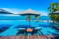 Beautiful luxury outdoor swimming pool in hotel resort with sea ocean around coconut palm tree and white cloud on blue sky Royalty Free Stock Photo