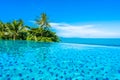 Beautiful luxury outdoor swimming pool in hotel resort with sea ocean around coconut palm tree and white cloud on blue sky Royalty Free Stock Photo