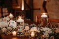 Beautiful luxury rustic wedding guest table decor - wooden tables with glass jars and candles, white roses and eucayptus leaves