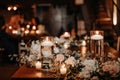 Beautiful luxury rustic wedding guest table decor - wooden tables with glass jars and candles, white roses and eucayptus leaves