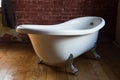 Beautiful luxury vintage bath on a wooden floor against a brick wall background