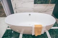 Beautiful luxury vintage empty bathtub near big window in bathroom interio, free space. Royalty Free Stock Photo