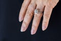 Beautiful and luxury wedding diamond ring worn on woman hand on black fabric background Royalty Free Stock Photo