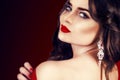 Beautiful luxury woman with jewelry, earrings. Beauty and accessories. brunette girl with big red lips in a red dress.